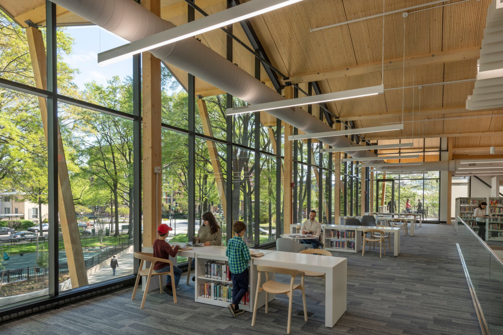a group of people sitting at tables in a library