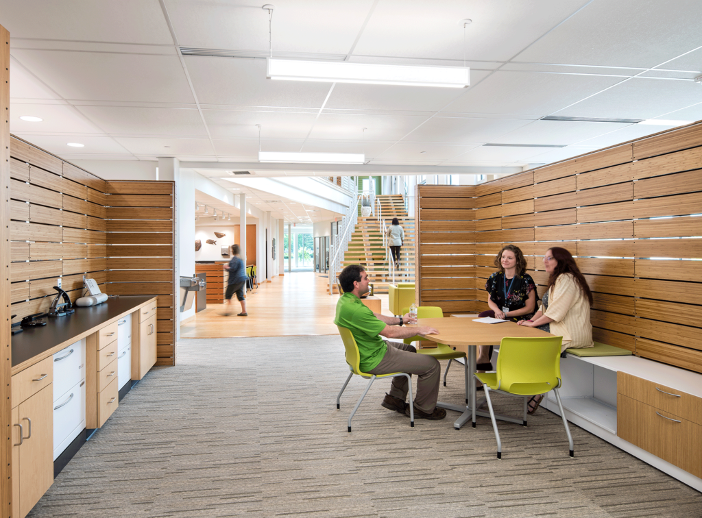 a group of people sitting at a table in a room with stairs