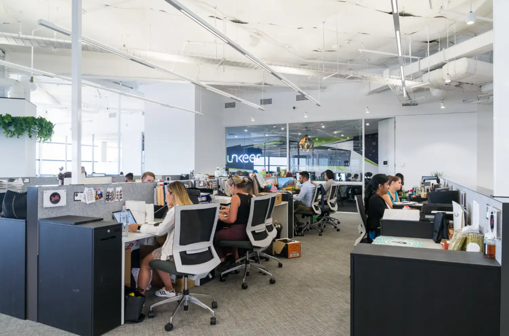 a group of people sitting at desks in an office