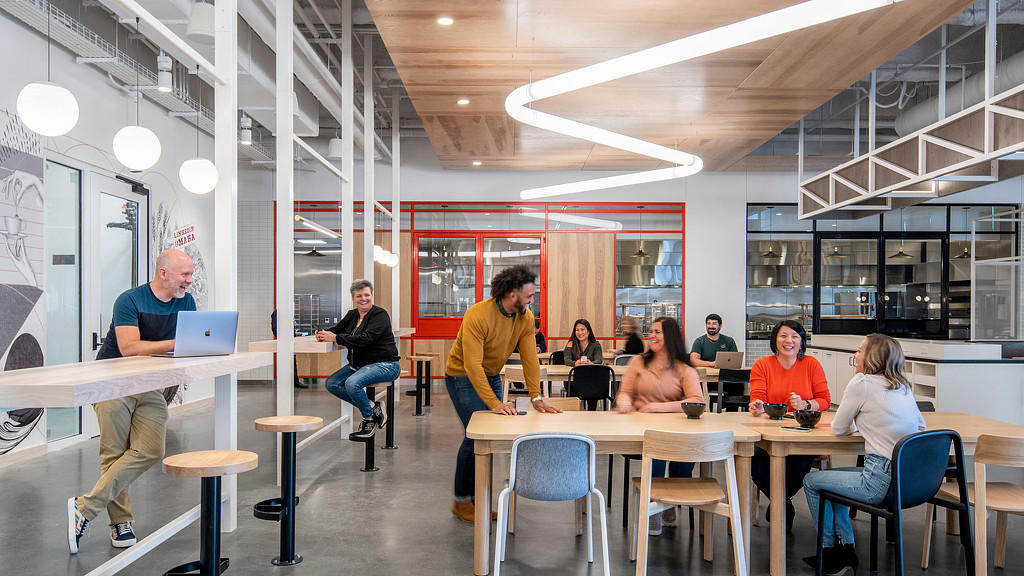 a group of people sitting at tables in a room with red walls