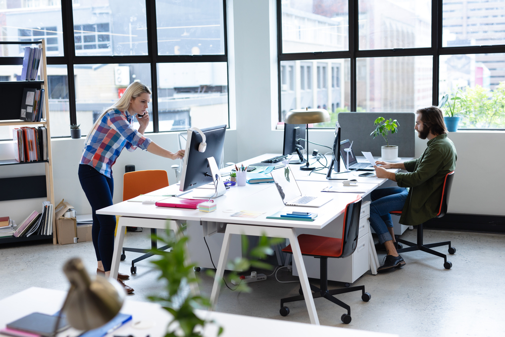 Office Sharing vs. Coworking – What’s the Difference? Modern office with two employees working.