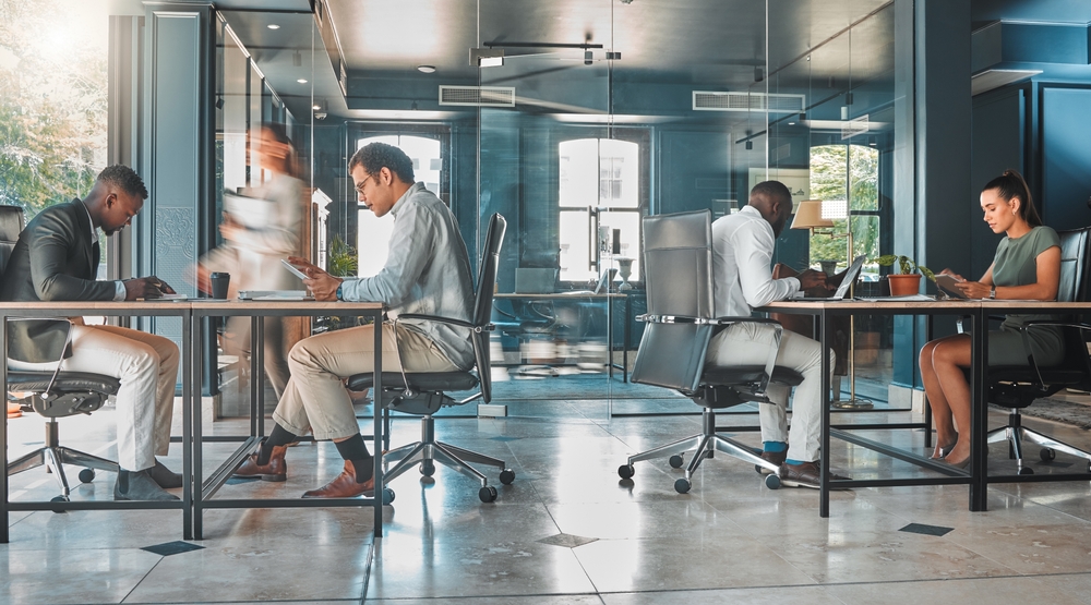 Office Sharing vs. Coworking – What’s the Difference? Modern office with people working.