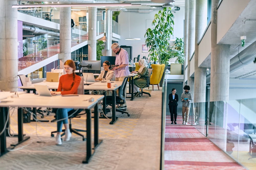 Office Sharing vs. Coworking – What’s the Difference? Modern office with people working.