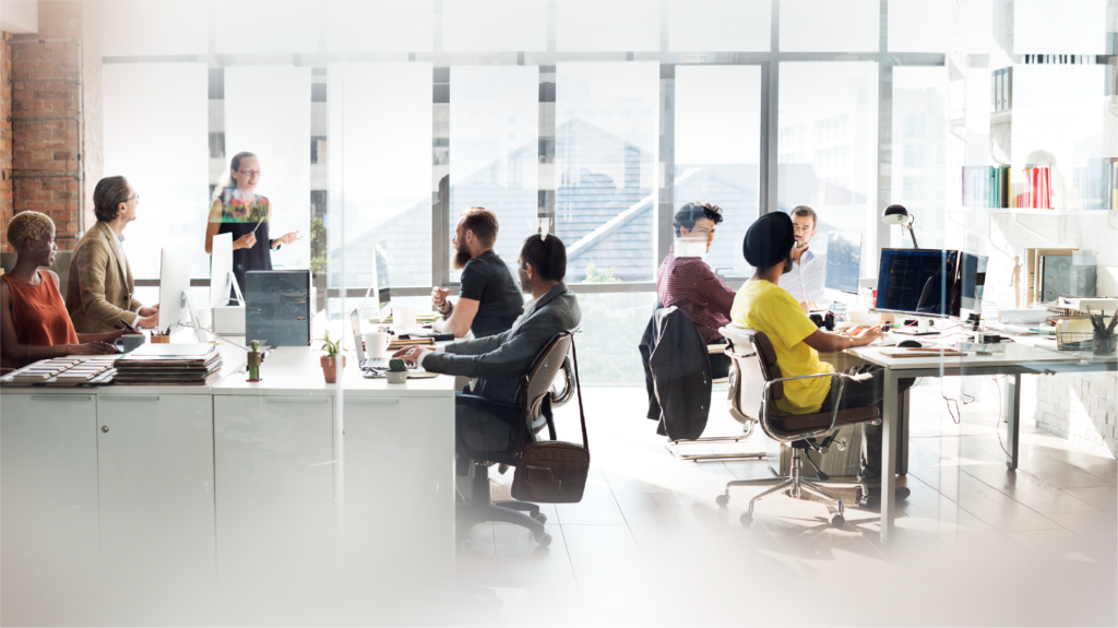 Nine benefits of coworking spaces a group of people sitting at desks in a room