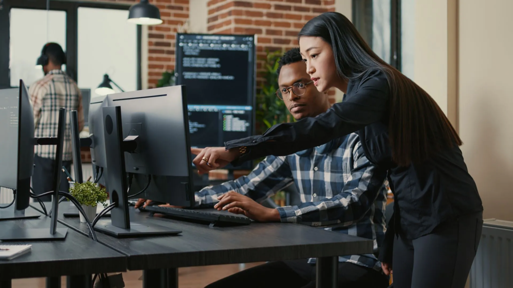 a man and woman looking at a computer screen