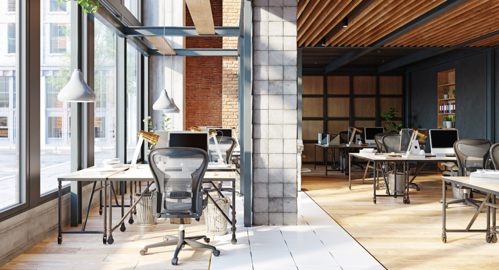 a room with a large brick wall and a large desk with computers