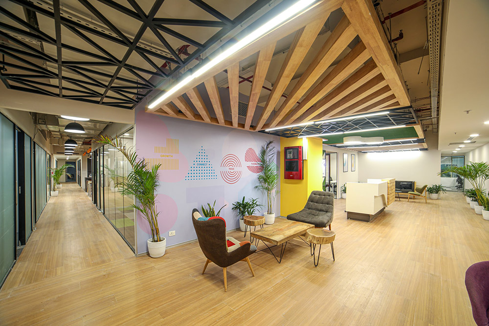 What is a collaboration hub? a room with a wood floor and a wall with a table and chairs