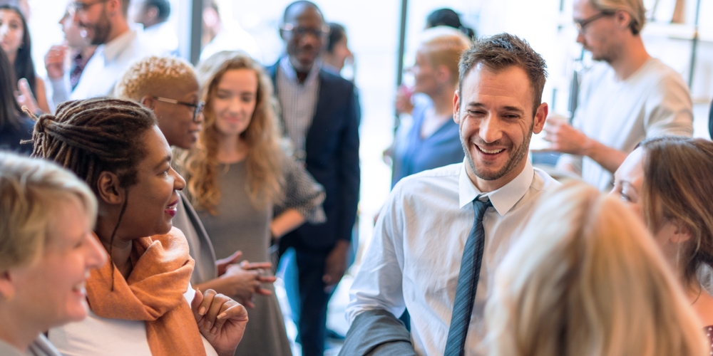 12 benefits of a collaborative workspace Crowded social gathering with diverse attendees.