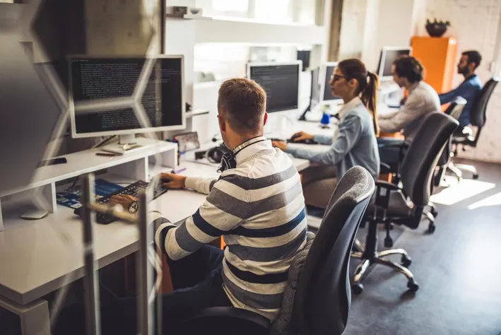 Technology in the Workplace: Advantages, Importance, and Influence a group of people working on computers