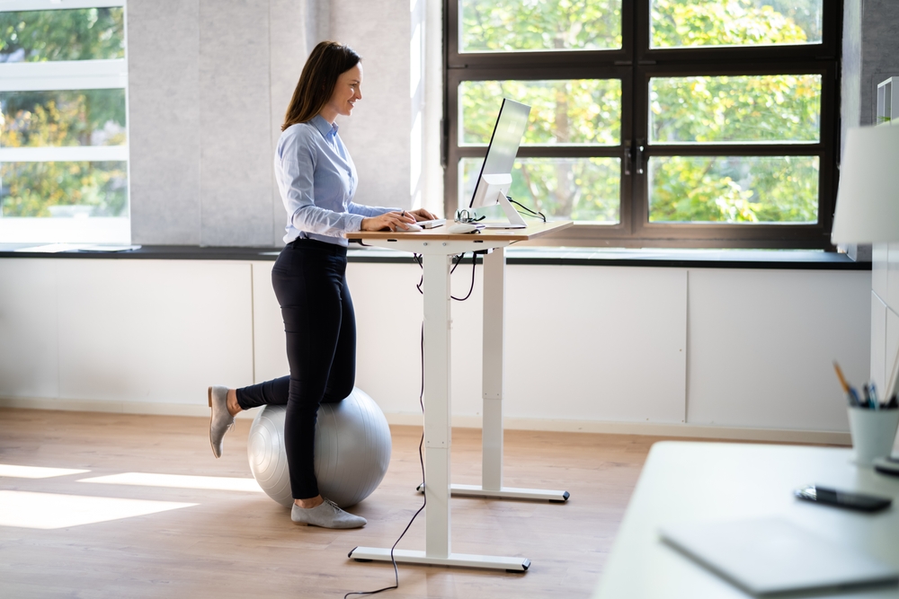 Five ways to set up your desk for productivity Woman working at standing desk